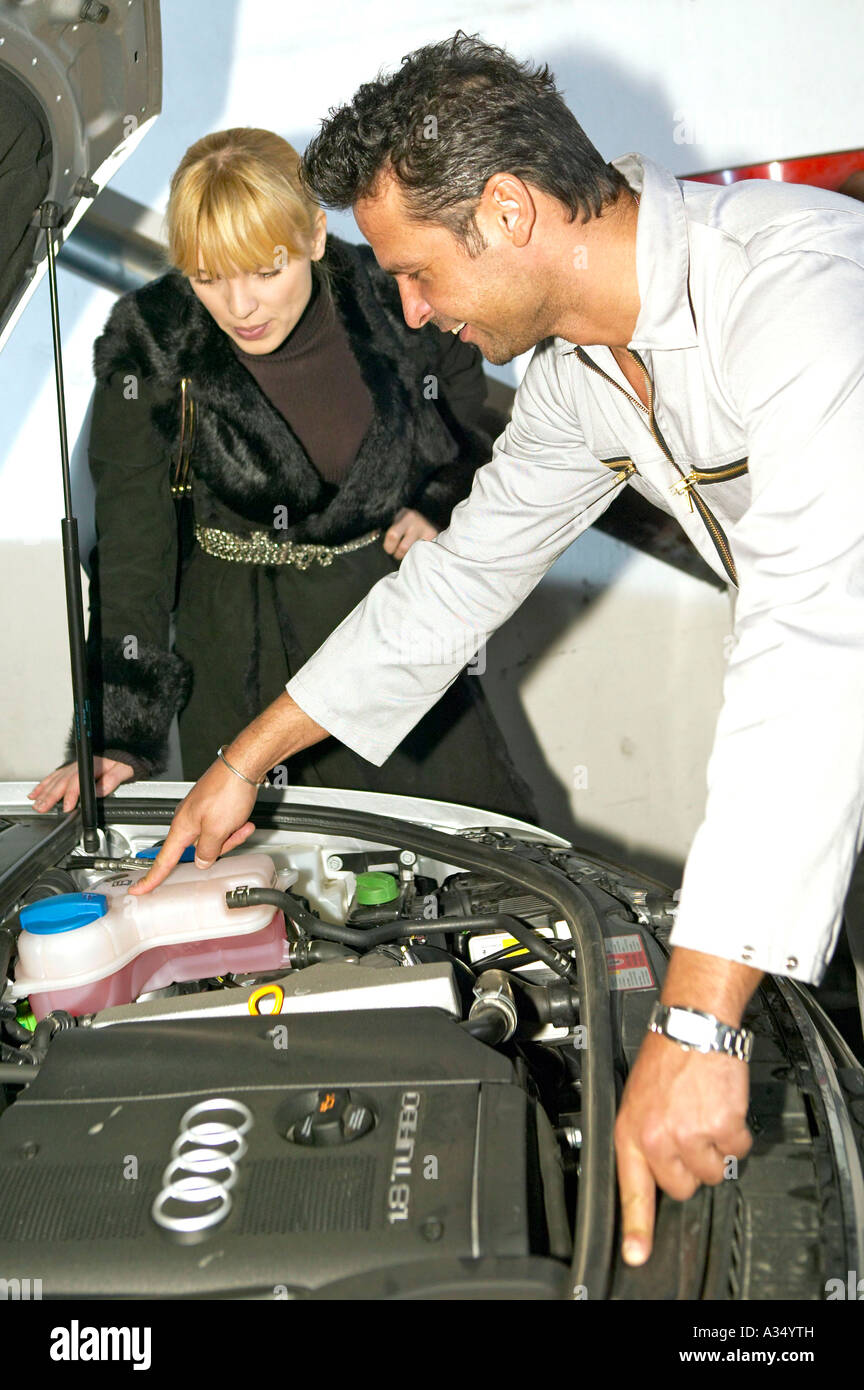 Frau unterhaelt sich mit einem Mechaniker in der Werkstatt, woman in garage talking to mechanic Stock Photo