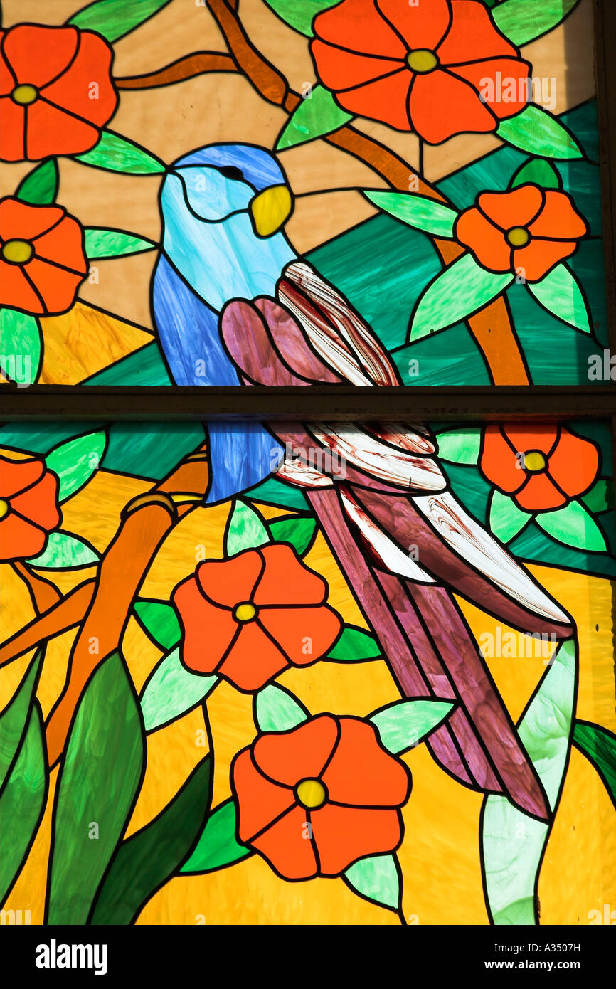 Colourful stained glass window of parrot perched in a tree, Trinidad