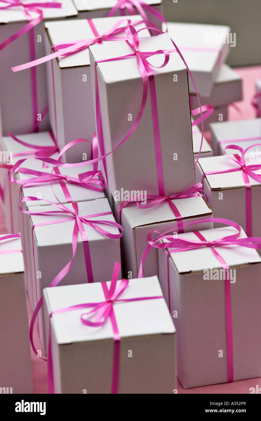 A stack of small white gift boxes, tied with pink ribbons. Stock Photo