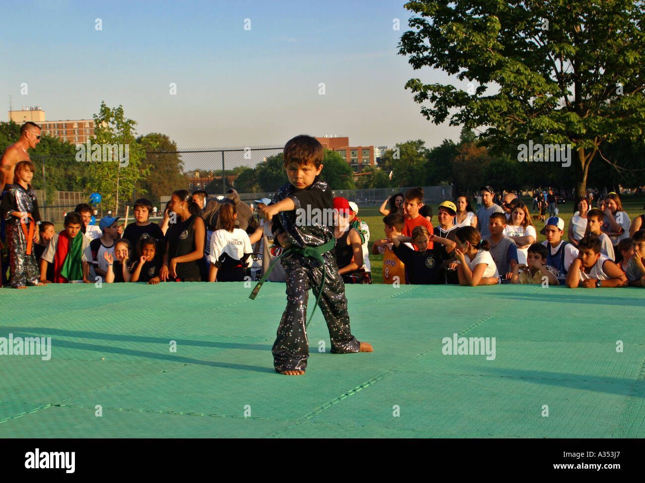 Young boy demonstrating a Karate move on an outdoor stage in the park. Teenage audience observing. Toronto, Ontario, Canada Stock Photo