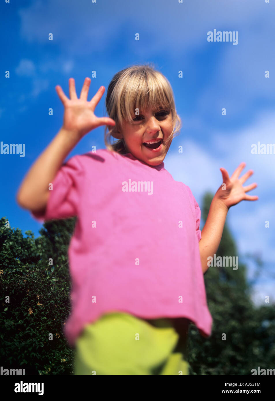happy young girl with both hands in the air. Stock Photo
