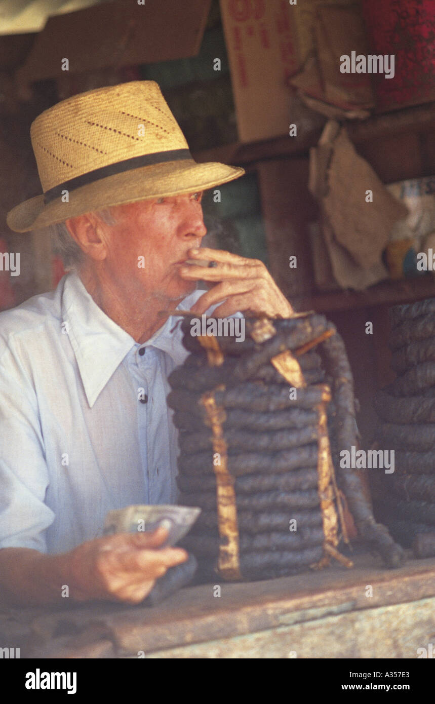 Nazare Bahia Brazil Man selling tobacco rope smoking a cigarette and wearing a straw hat Stock Photo