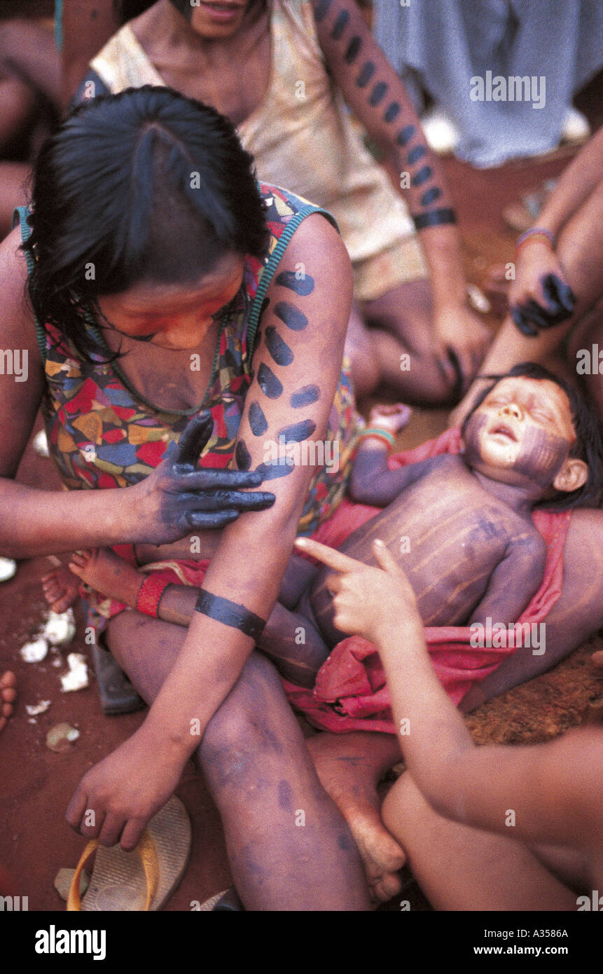 A Ukre village Brazil Kayapo woman applying black genipapo body paint dye to her arms Xingu Indigenous Reserve Stock Photo