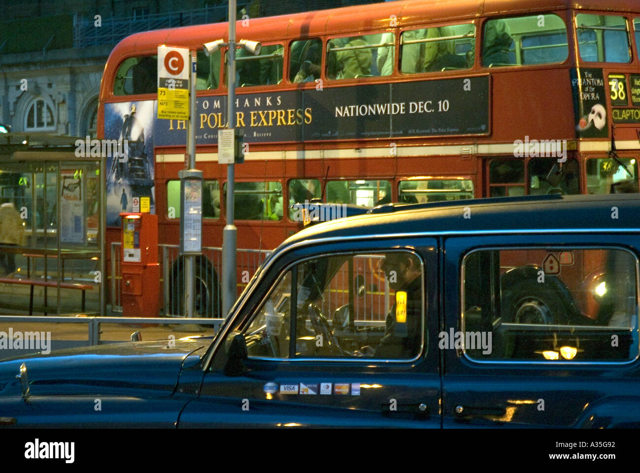 A black taxi and Red double decker bus outside Victoria Station in ...