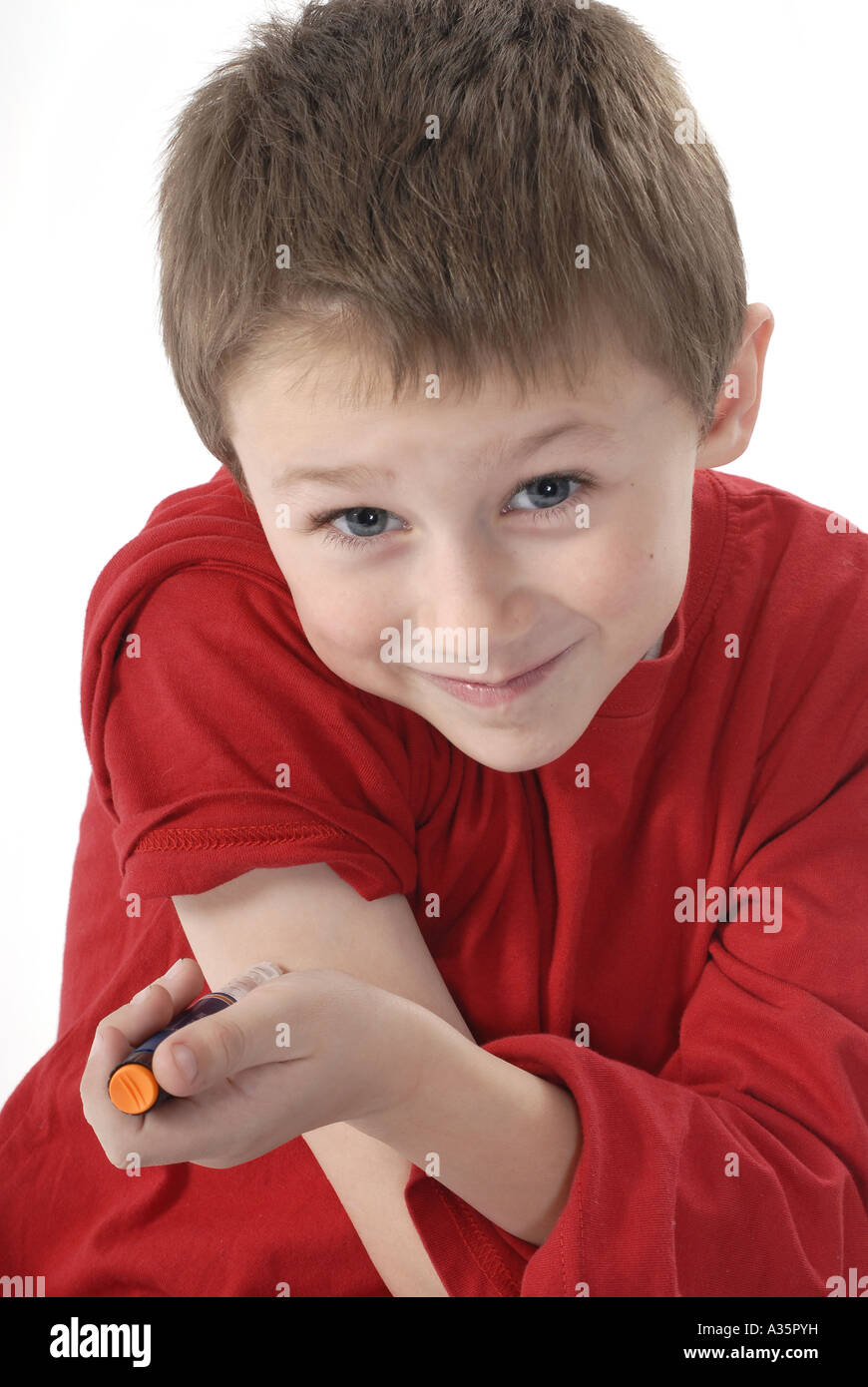 Young diabetic boy giving himself an insulin injection in the arm Stock