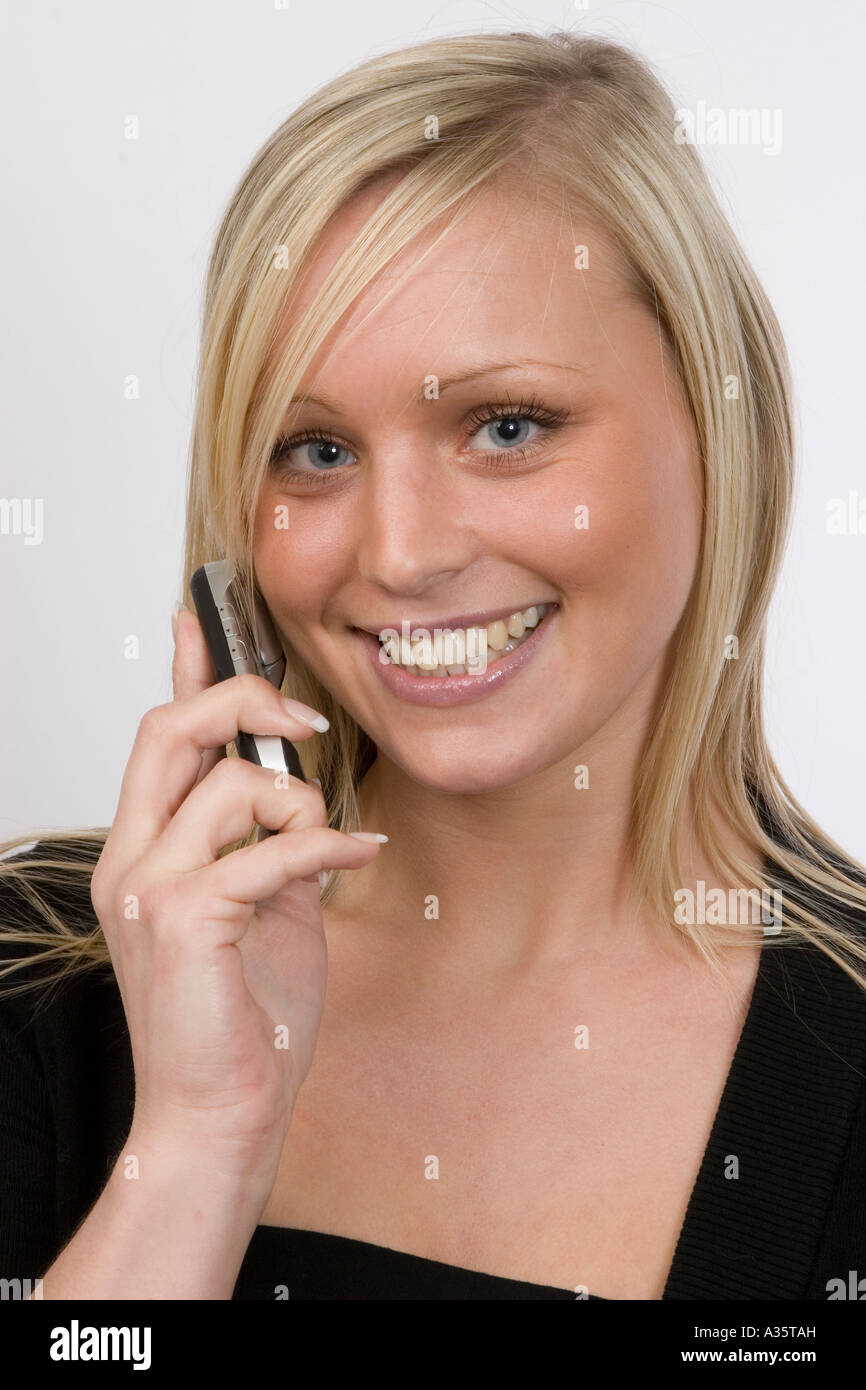 Young Woman Smiling, using a Mobile Phone Stock Photo