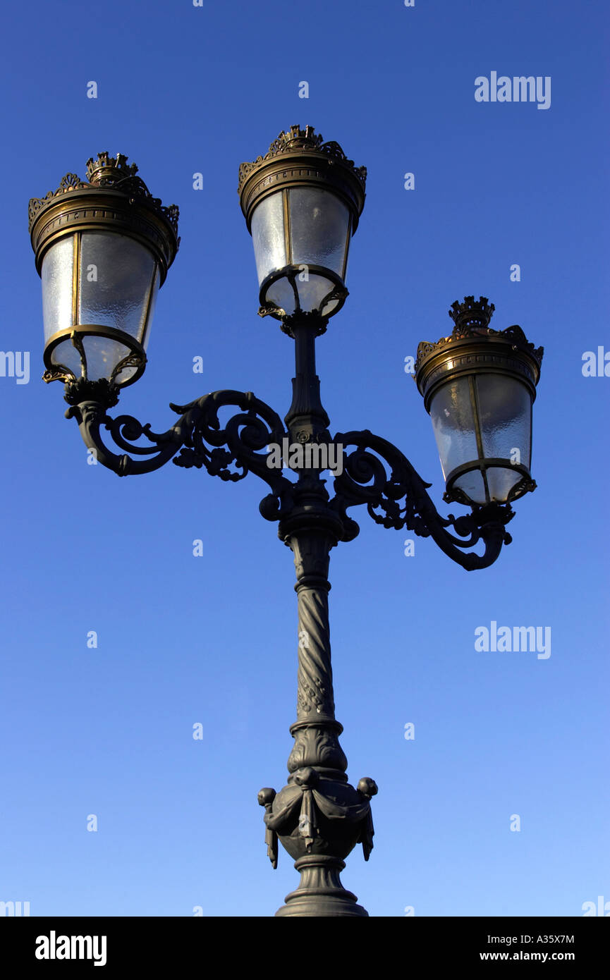 old gas street lamps now electric lights on bridge over the liffey in O Connell street Dublin vertical Stock Photo
