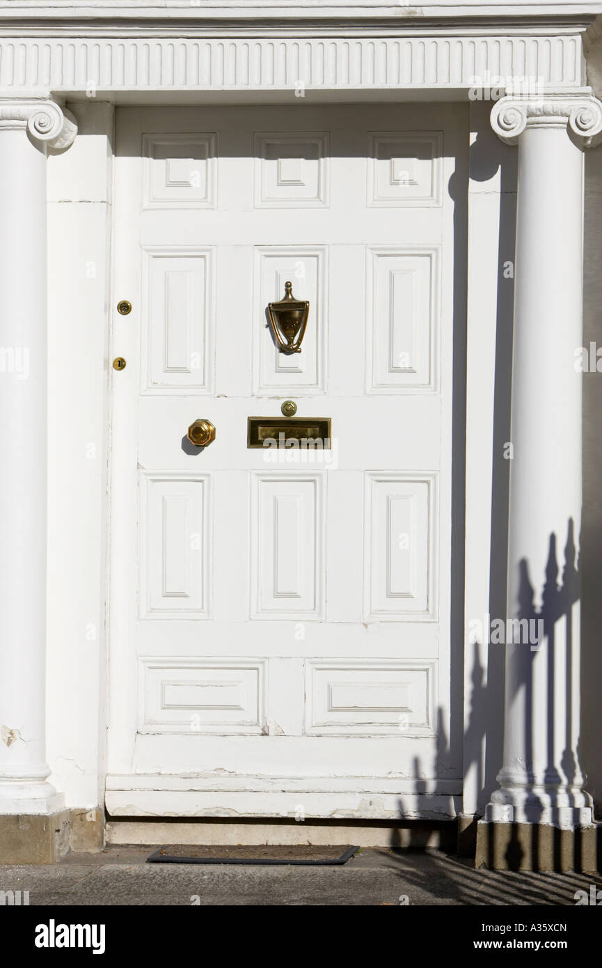 white door with brass letterbox door knob and knocker in
