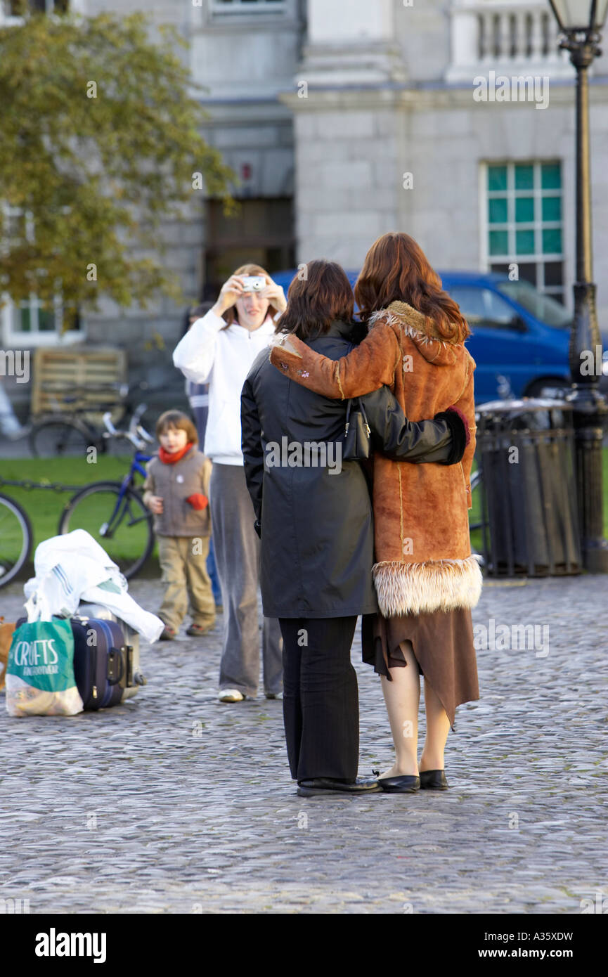 tourists taking posed photos in parliament square inside Trinity College Dublin University of Dublin Stock Photo