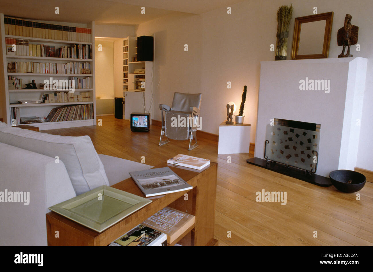 Modern sittingroom with polished wood floor and white settee and