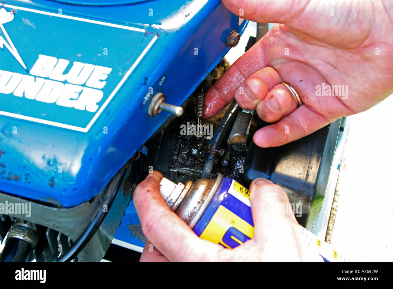 MOWER MAINTAINENCE LUBRICATE LINKAGES ON CARBORETTER Stock Photo Alamy