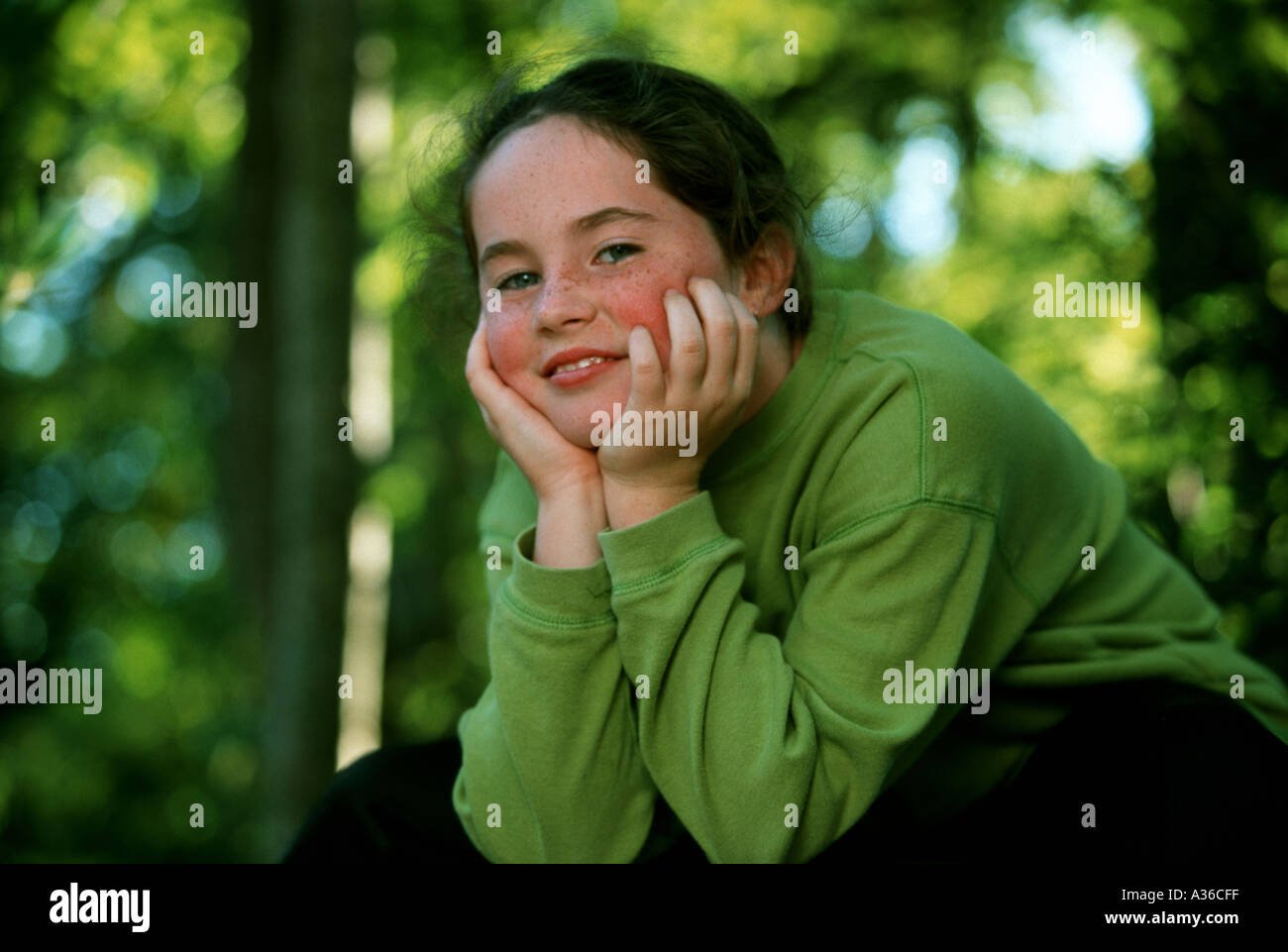 A beautiful girl with long brown hair and wearing a green shirt is ...