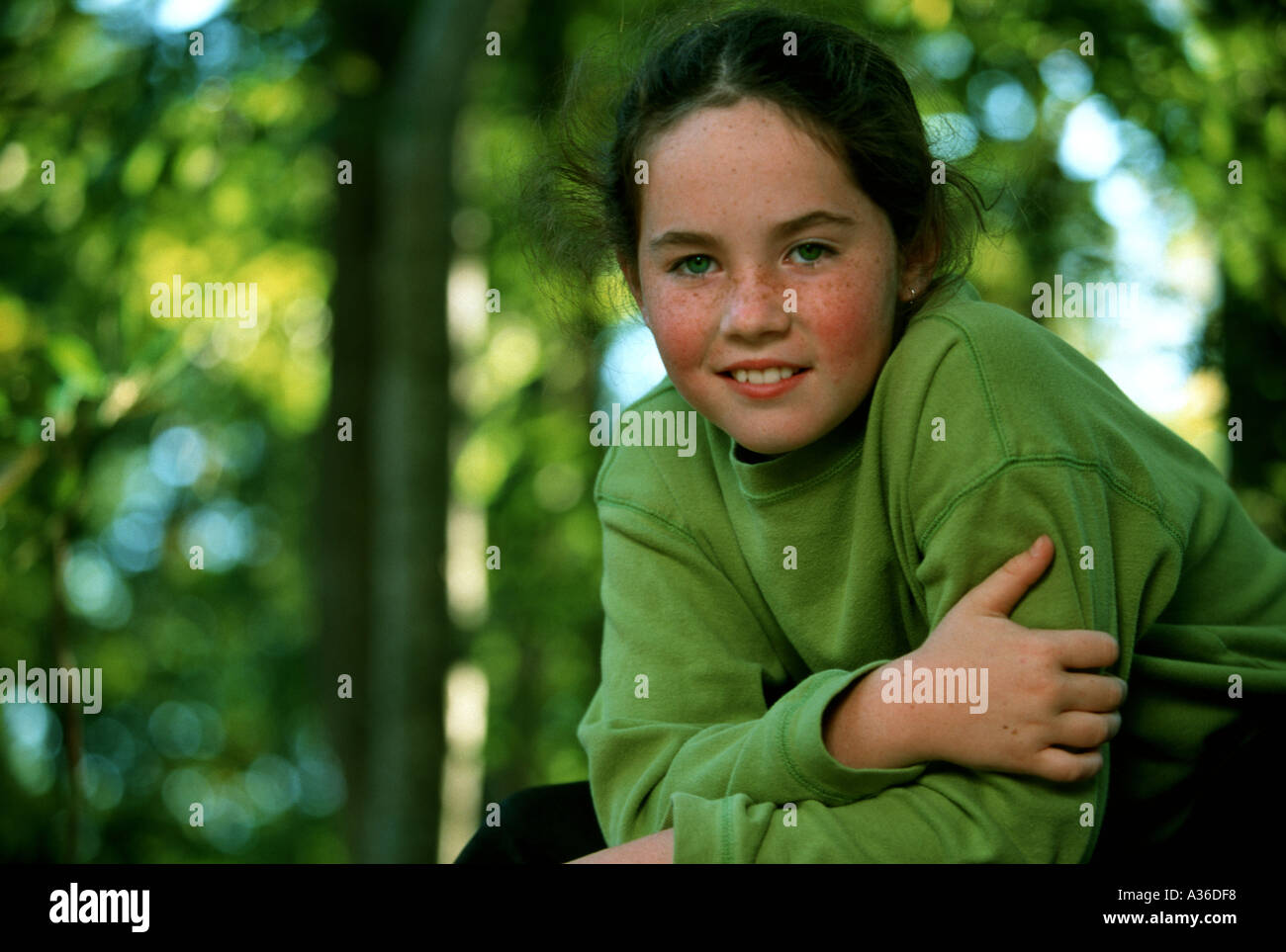A beautiful girl with long brown hair and wearing a green shirt is ...