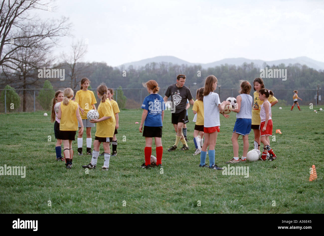 A girl s soccer team gathers on the field for soccer practice Stock Photo