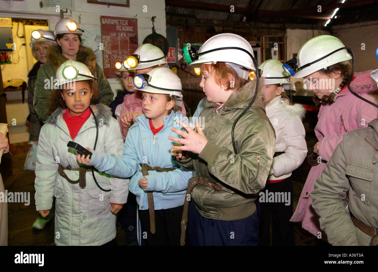 School party fitted with lamps and hard hats prepare to go underground at Big Pit National Coal Museum Blaenavon South Wales UK Stock Photo