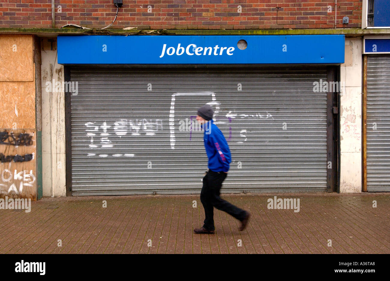 Closed Job Centre with graffiti and roller shutters in run down area at Symes Avenue Hartcliffe Bristol England UK Stock Photo