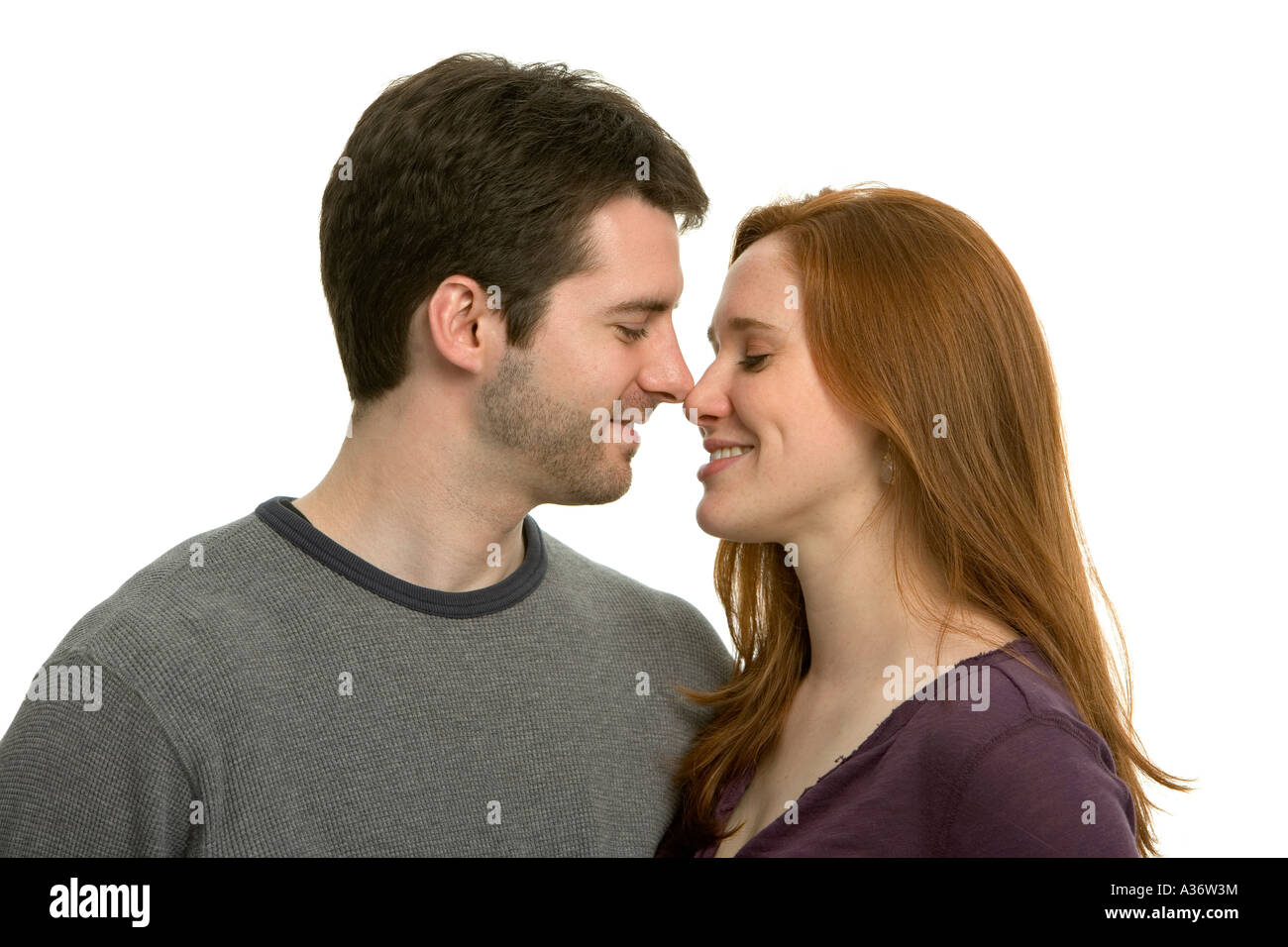 Happy young couple smiling and sharing a secret in a private moment Stock Photo