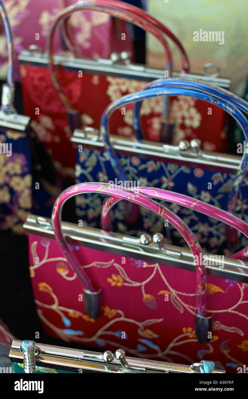 Chinese imitation silk brocade handbags, close-up. Bright blue, red and fuschia colors. Stock Photo
