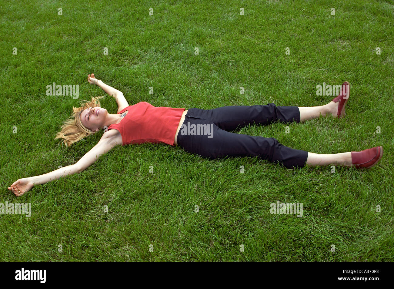 Woman Lying In Grass With Arms And Legs Spread Out Stock Photo Alamy