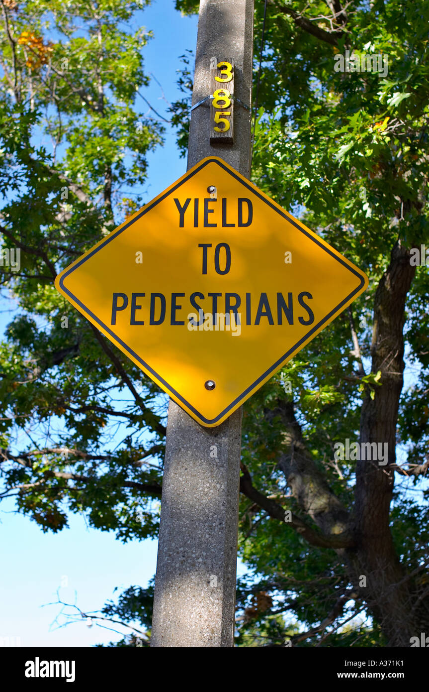 Yield To Pedestrians Yellow Sign Posted On A Tree In A Wooded Area Stock Photo Alamy