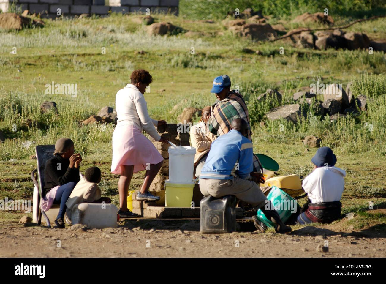 Villagers gather to collect water at the communal tap in the village of Semonkong in Lesotho. Stock Photo