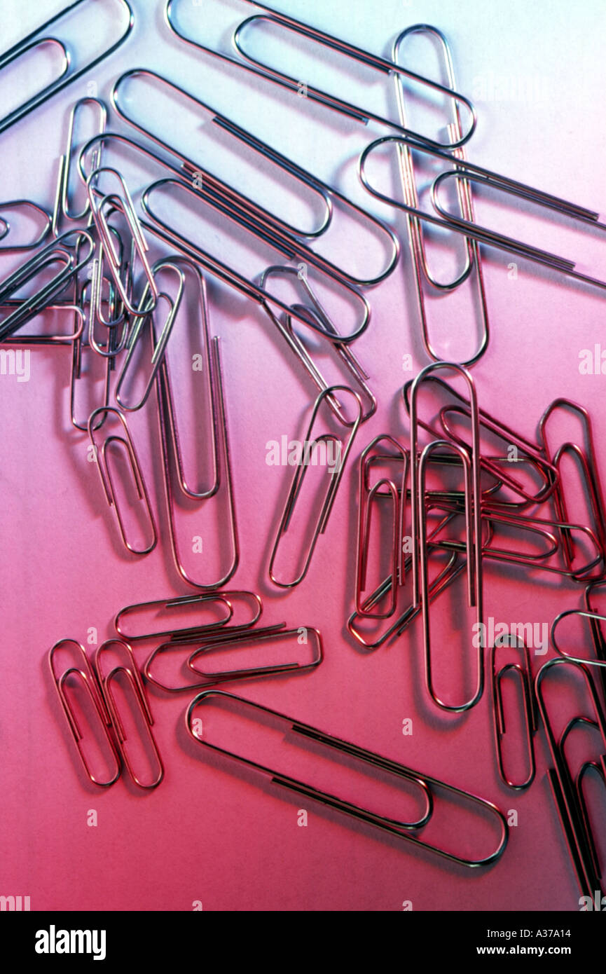 Paper Clips on red coloured background Stock Photo
