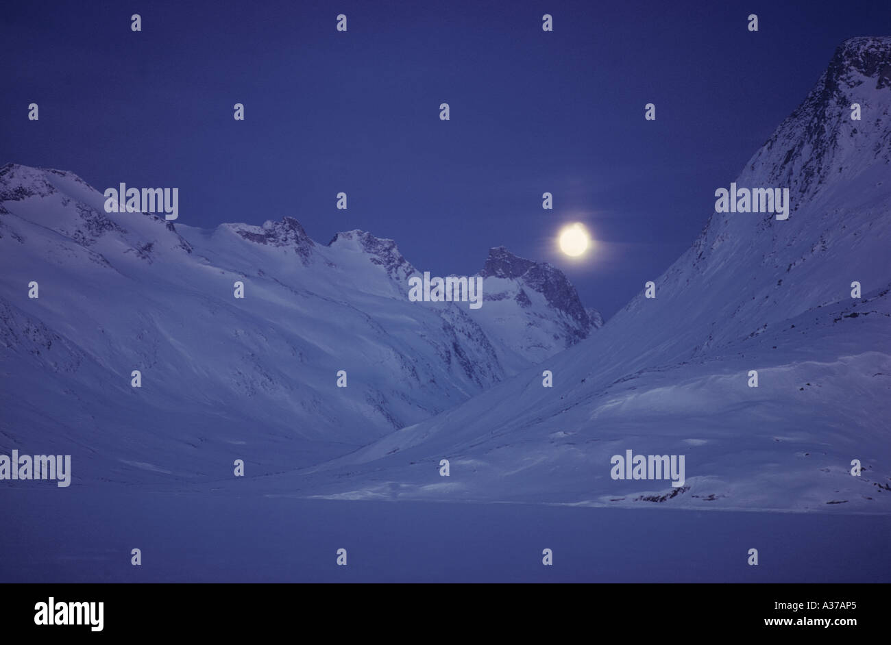 Moonscape at Tiniteqilâq in East Greenland full moon over snow covered mountains Stock Photo