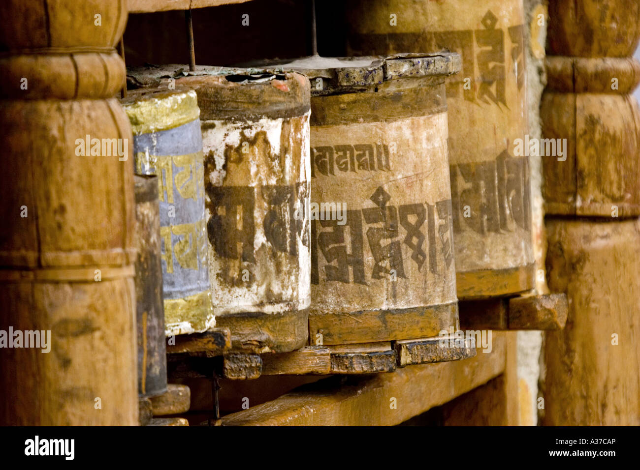 Old tibetan wooden prayer wheels with the mantra 'Om mani padme hum'. Stock Photo