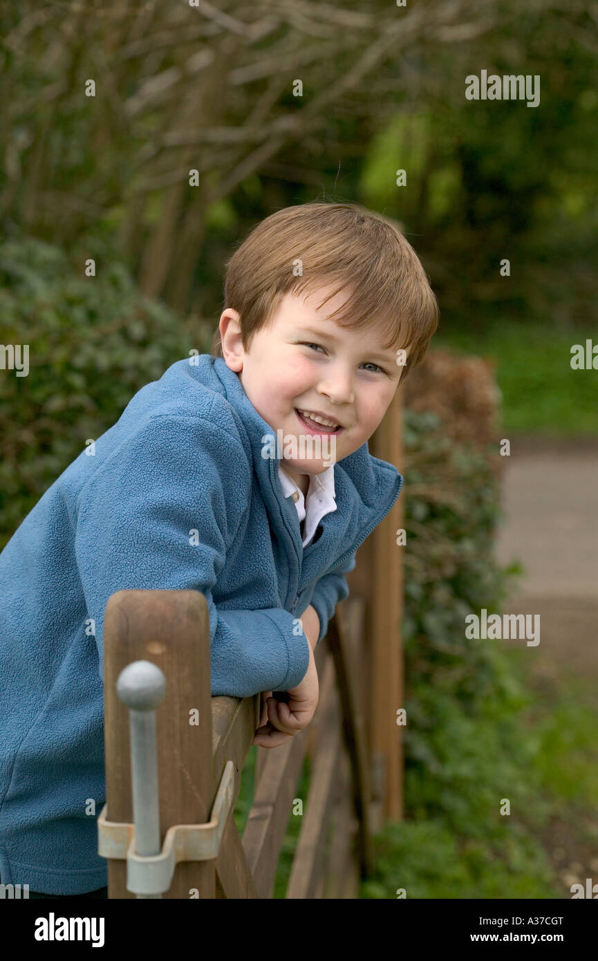 An image of a young boy leaning on a five bar gate Stock Photo