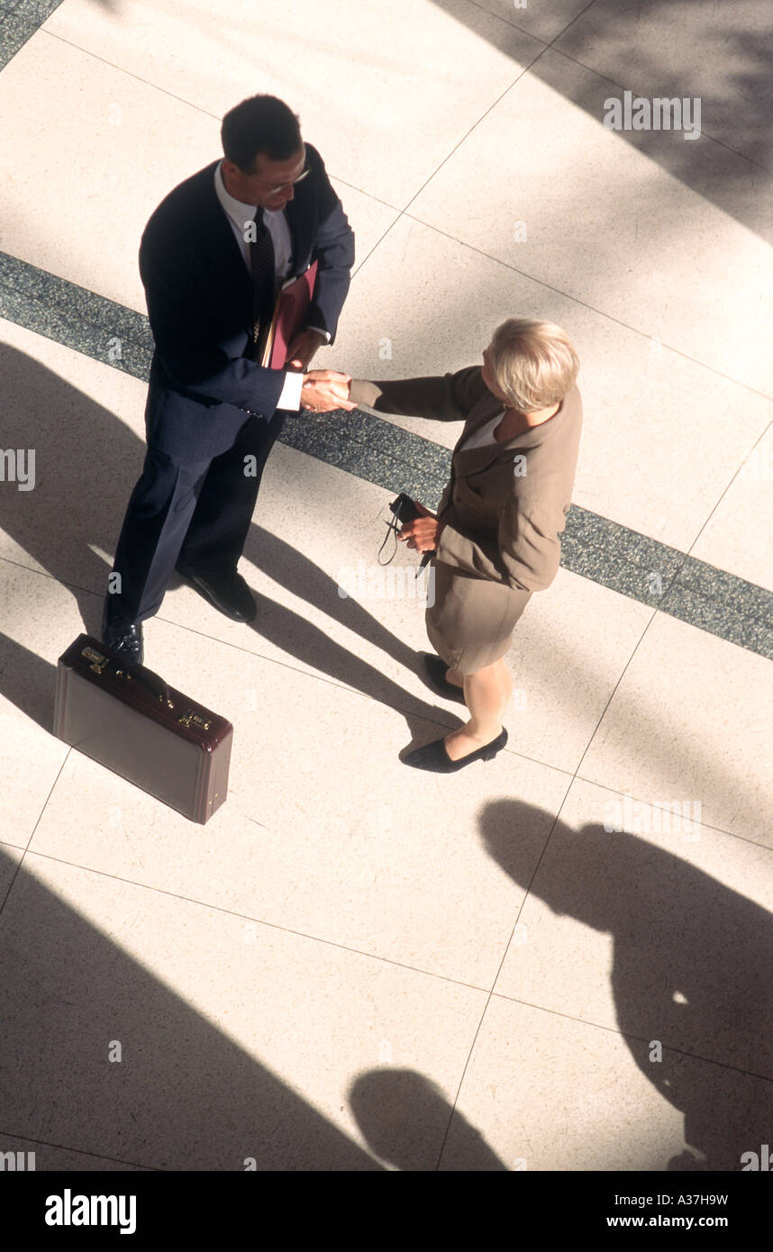 Businessman and businesswoman shake hands Stock Photo