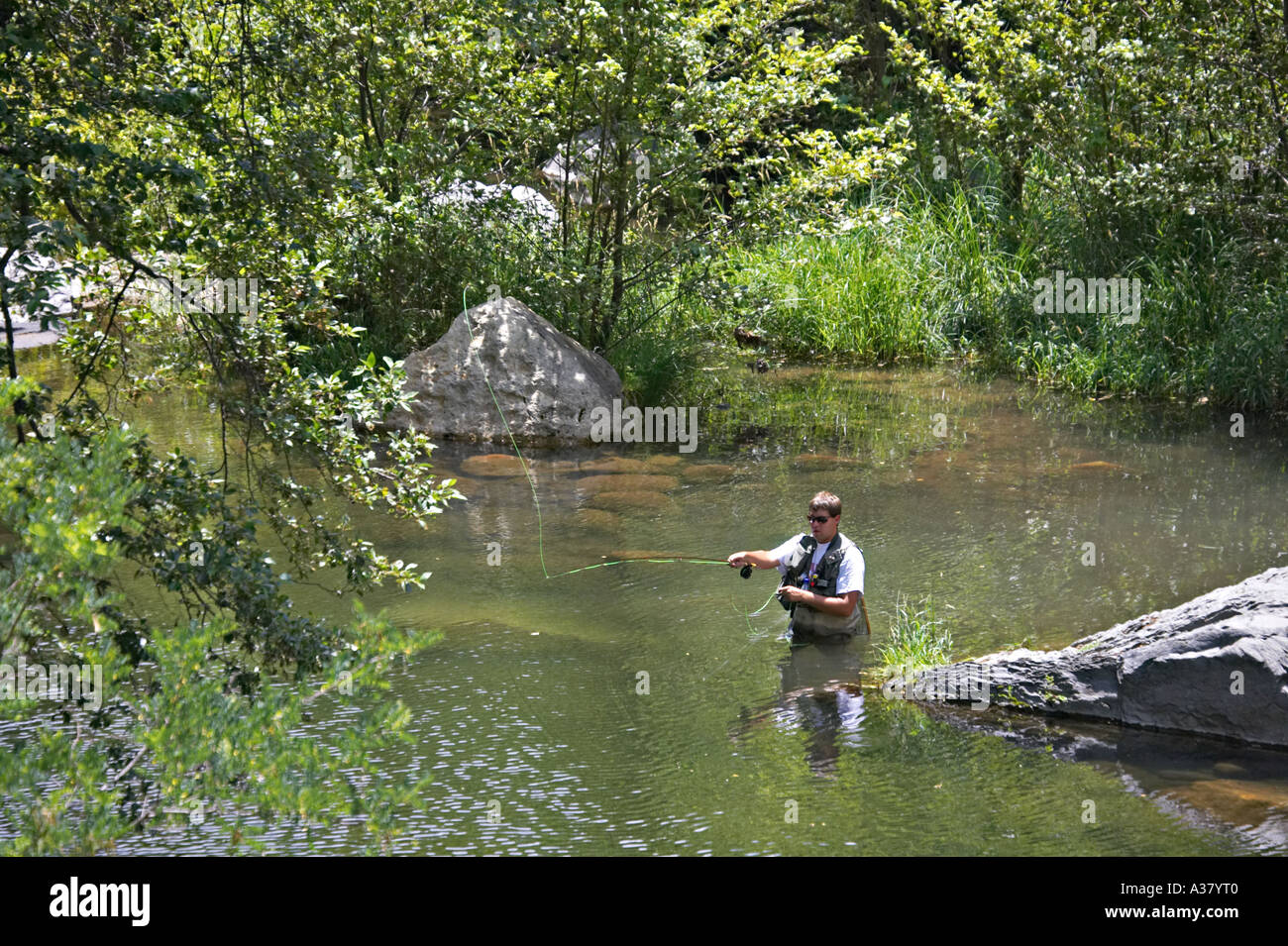 ARIZONA Sedona Teenage boy fly fish in Oak Creek narrow with trees along  banks waders and fly rod casting line deep water Stock Photo - Alamy