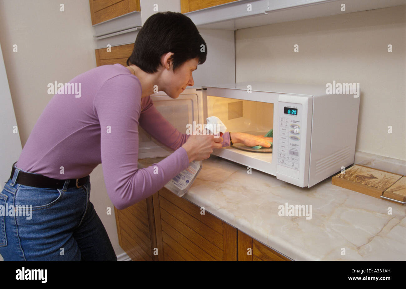 woman cleaning microwave Stock Photo