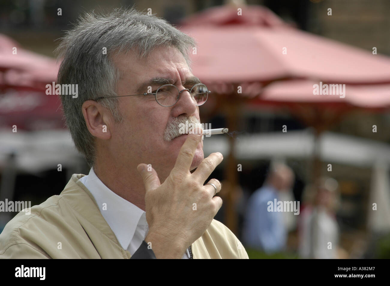 Aelterer Mann Rentner Senior raucht Raucher Nikotin Sucht grau grauhaarig Stock Photo
