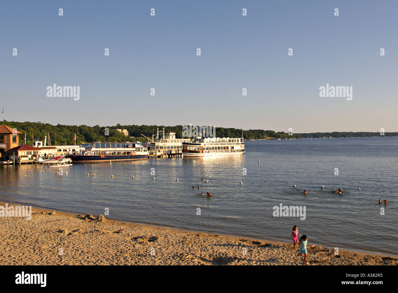 WISCONSIN Lake Geneva Paddlewheel tour boats at dock people on beach