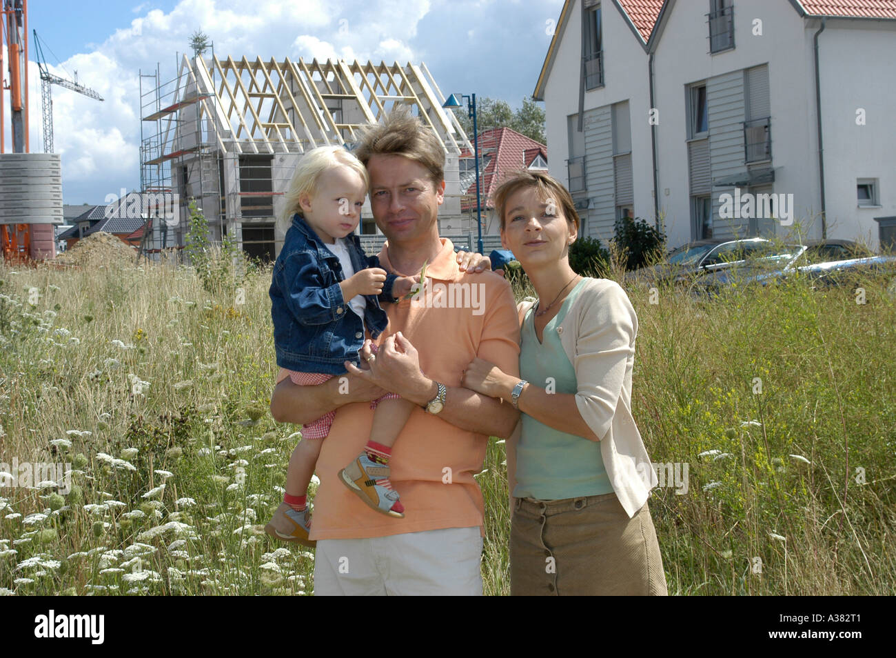 Junge Familie Eltern Vater Mutter Kind Eigenheim Neubau Bausparen Bauen Hausbau Bausparvertrag Stock Photo