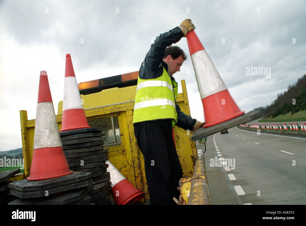 worker laying out traffic cones on the road Stock Photo - Alamy