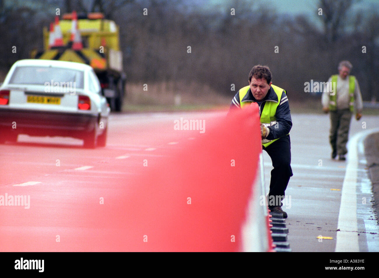 worker laying out traffic cones on the road Stock Photo - Alamy