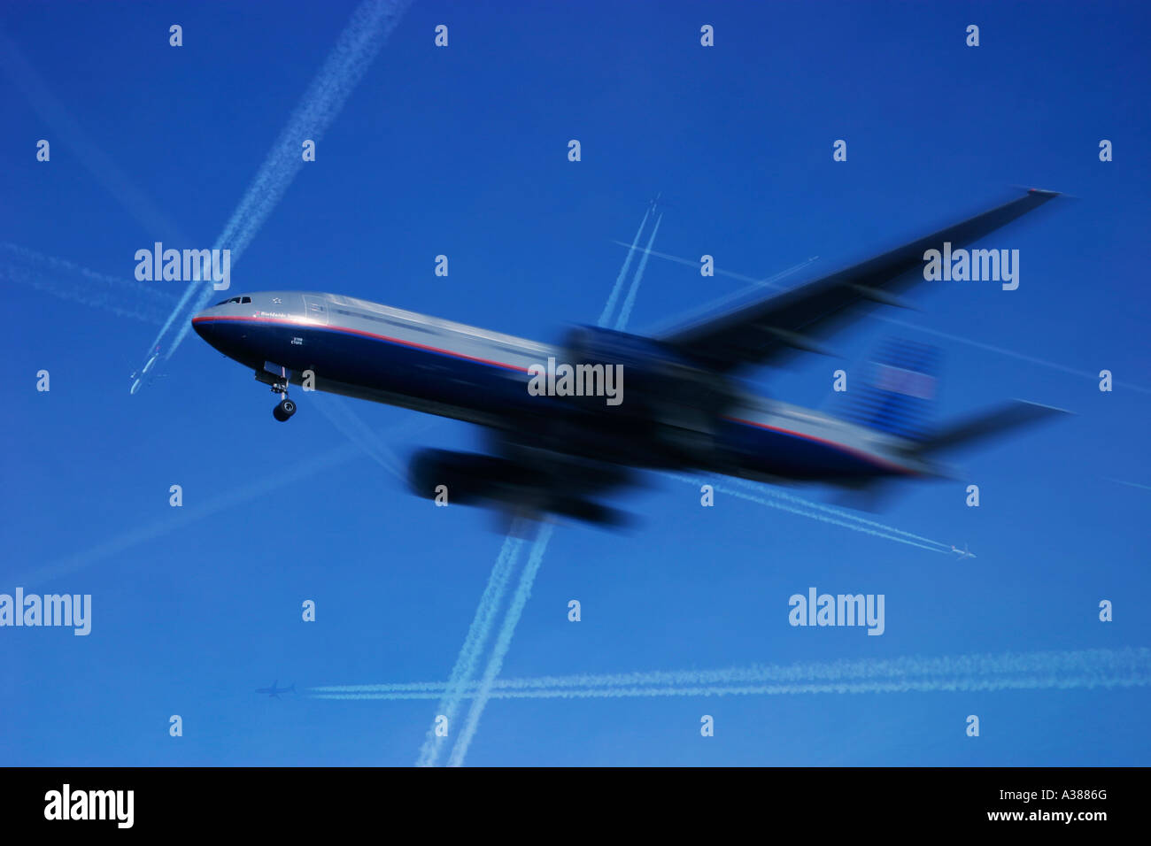 Commercial airplane in flight with many other airlineres above passing at high altitude Stock Photo