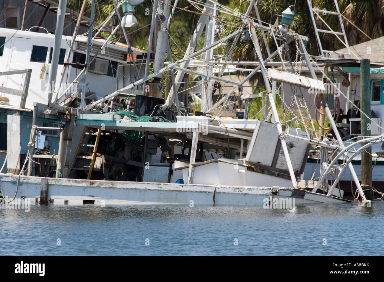 A Large White Shrimp Boat Sits on the Bottom After Sinking at the Dock Stock Photo