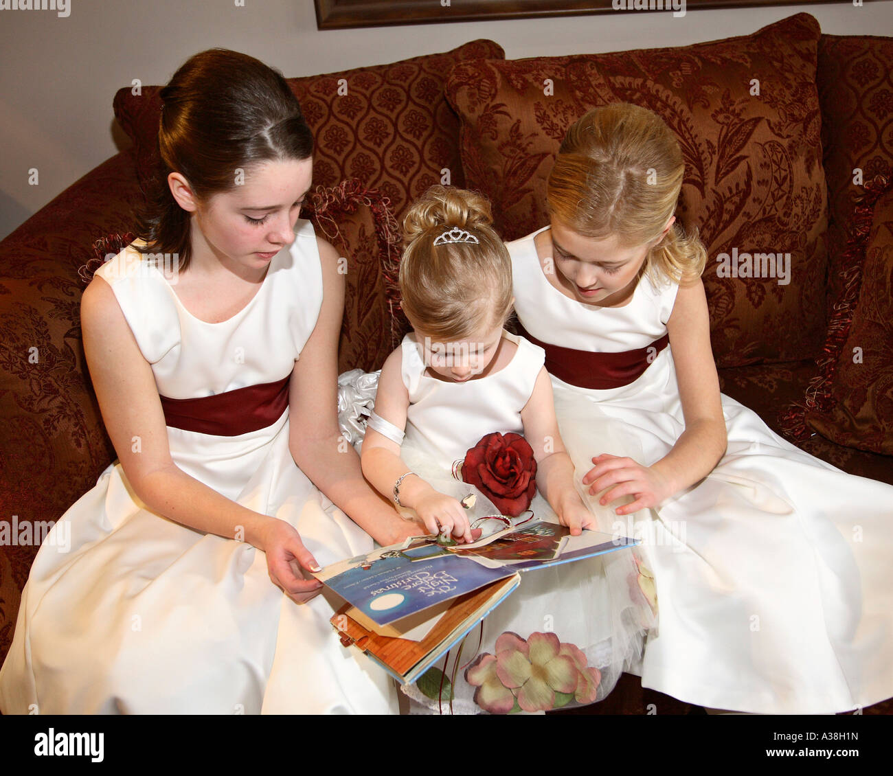 three flower girls reading wedding magazine Stock Photo