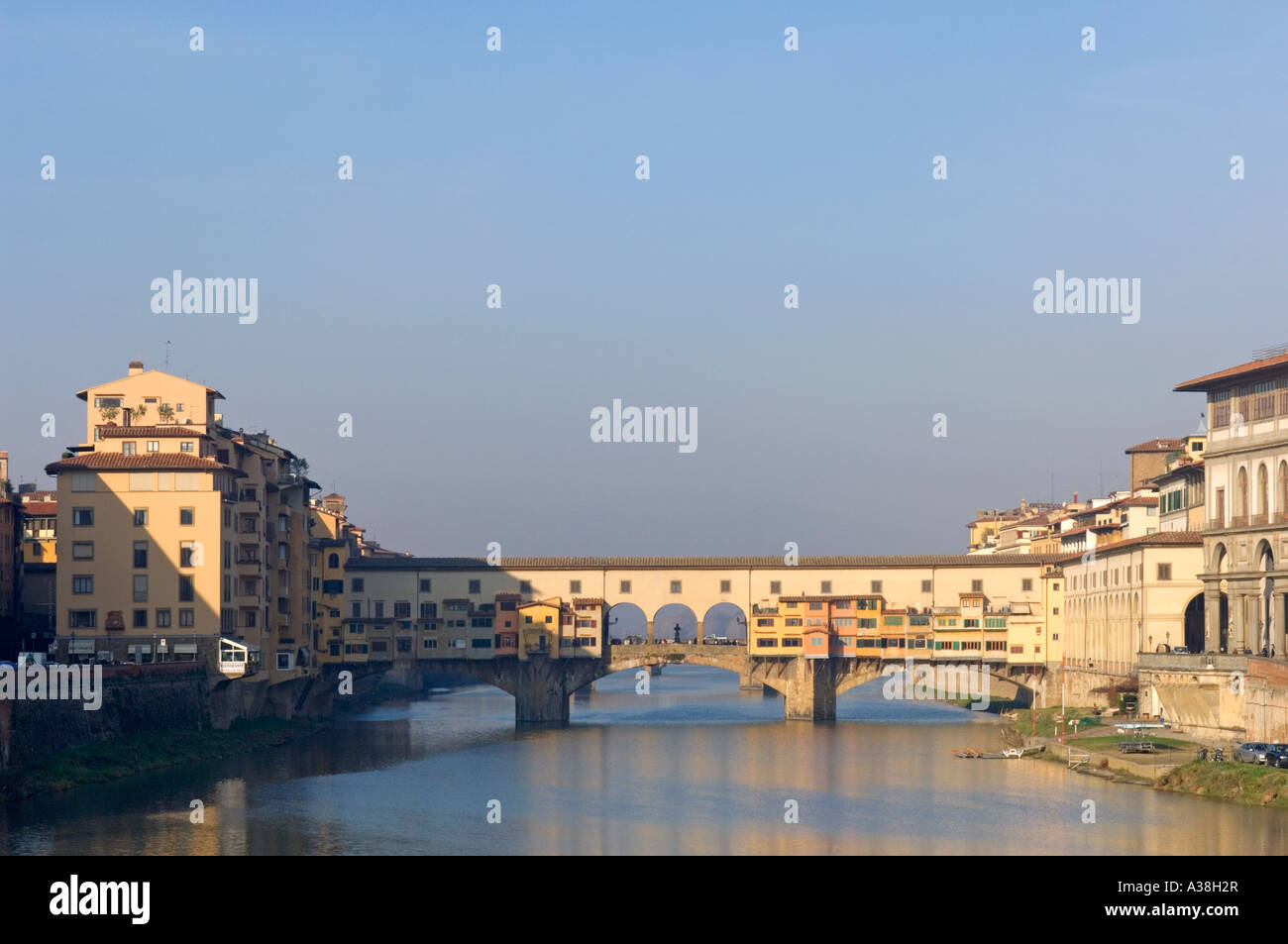 A wide view of the Ponte Vecchio bridge across the Arno river in Florence on a sunny day. Stock Photo