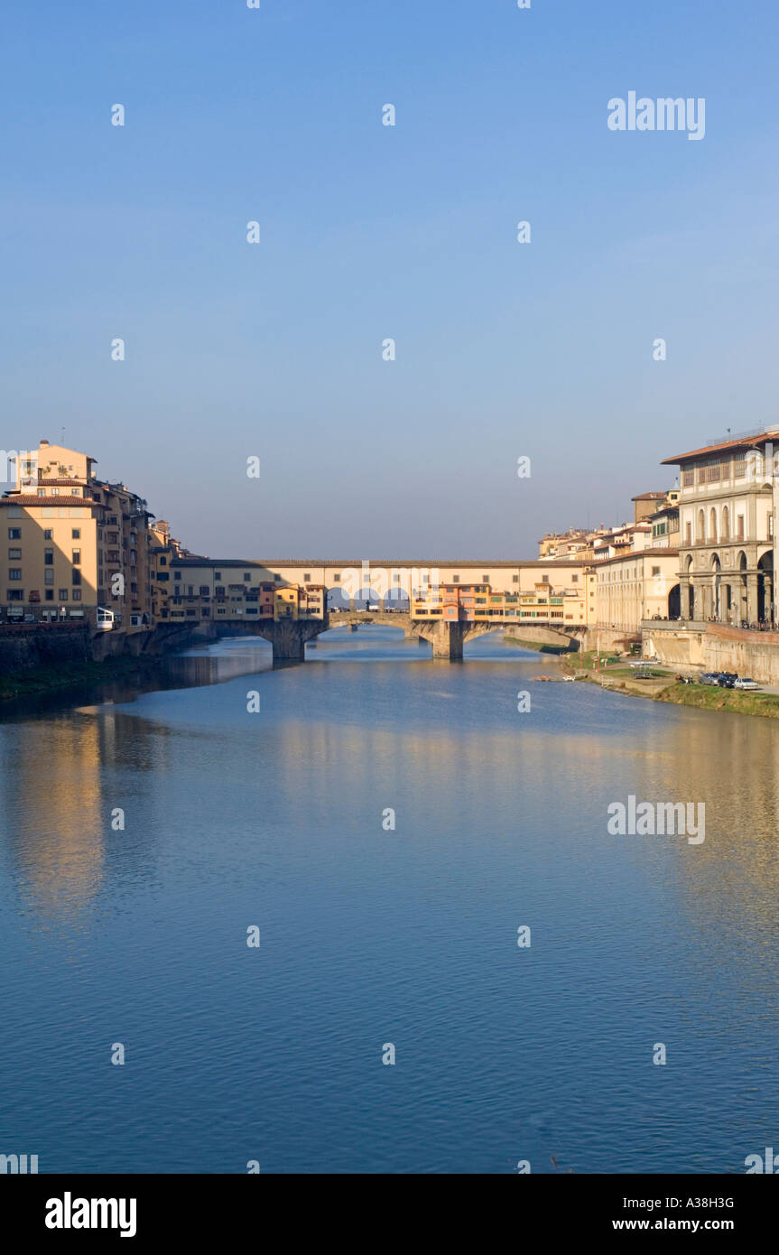 A wide view of the Ponte Vecchio bridge across the Arno river in Florence on a sunny day. Stock Photo