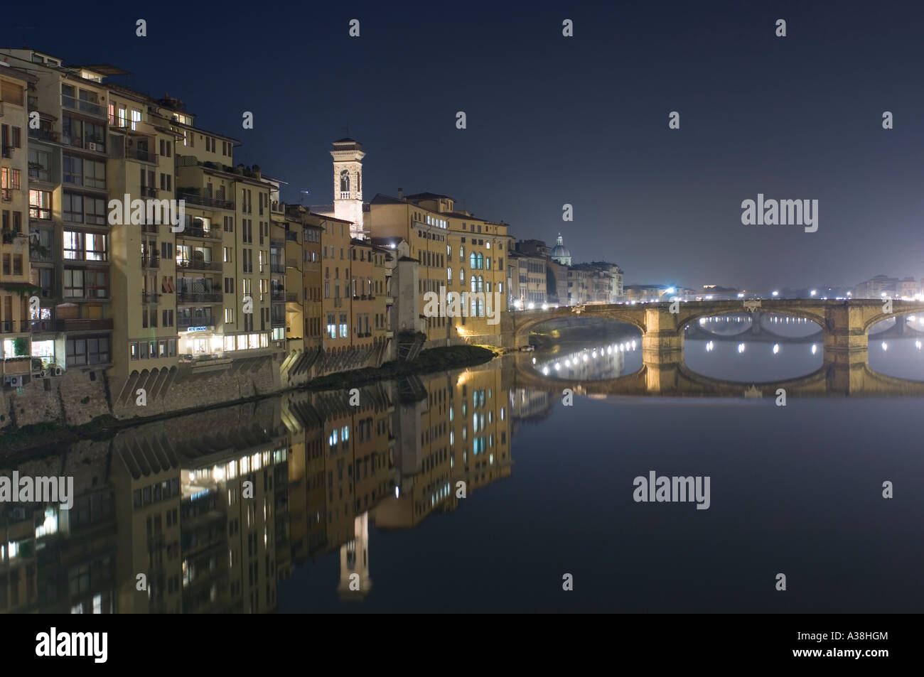 A view of the Ponte Santa Trinita (bridge) and buildings along Borgo San Jacopo reflected in the Arno river at night. Stock Photo