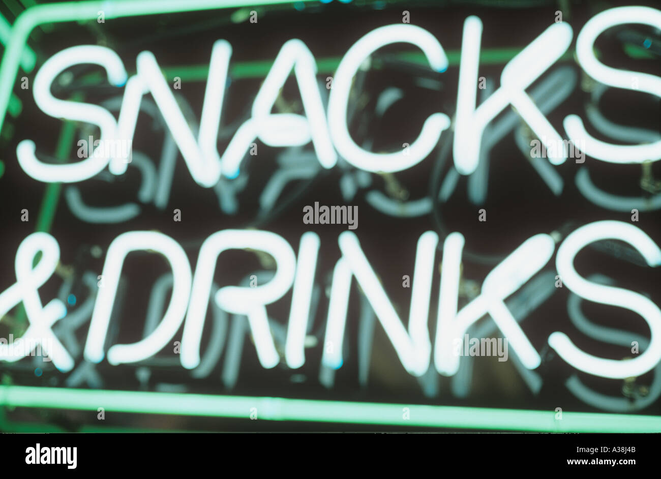 Defocussed green neon sign announcing Snacks and drinks Stock Photo