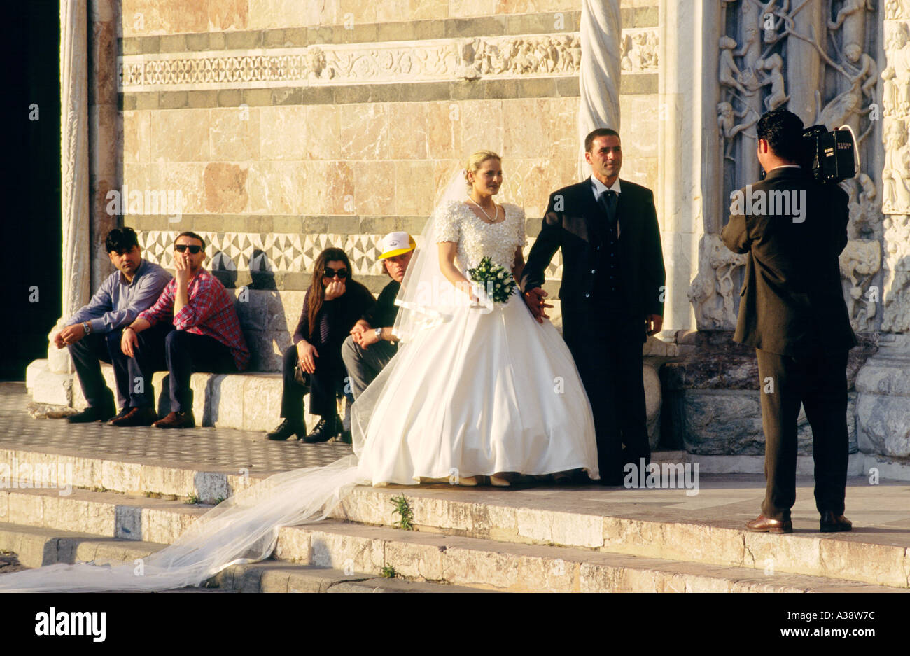 Messina Cathedral, Sicily, Italy. Bride and groom pose for wedding photographs video on steps of the west façade. Stock Photo