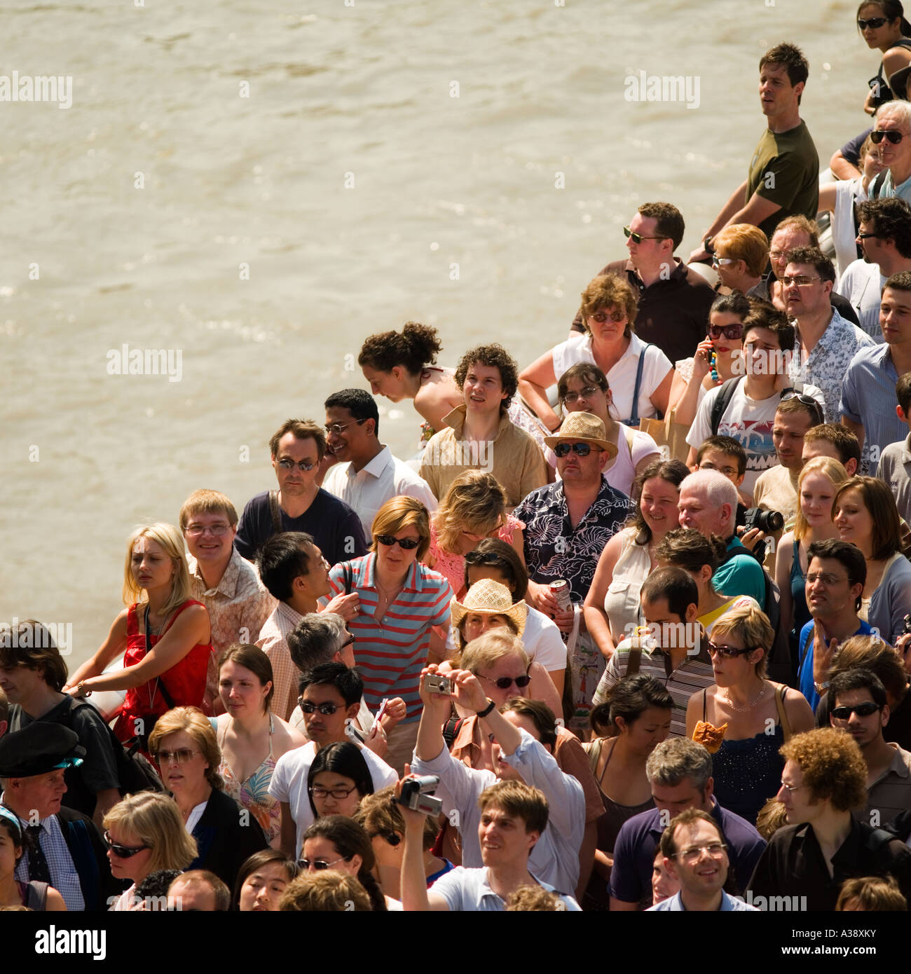 throng of people crossing Millennium Bridge over the River Thames throng of people crossing Millennium Bridge over the River Thames