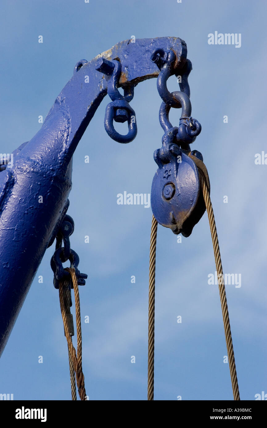 Block and tackle on fishing boat against blue sky Stock Photo
