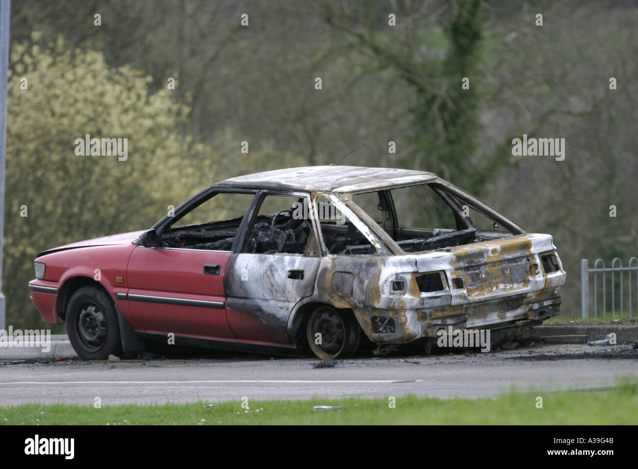 burnt out car by side of road loyalist monkstown estate county antrim northern ireland Stock Photo