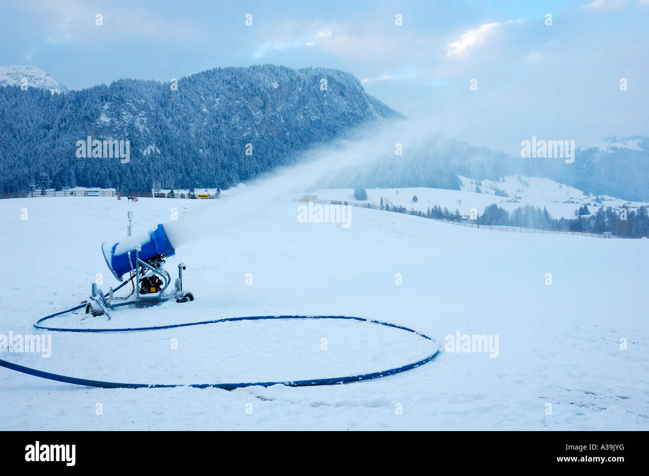Snow cannon gun, artificial snow making machine on the slopes of a ski  resort, ski lift and piste Stock Photo - Alamy