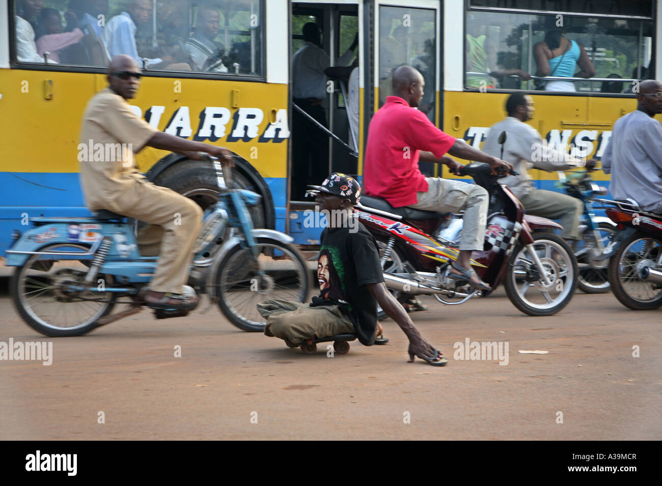 A beggar disabled by polio begging at traffic lights when the cars stop Bamako Mali, Africa Stock Photo